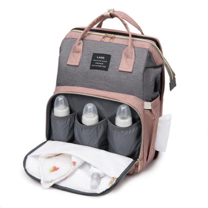 Poche avant du sac à langer avec trois emplacements pour biberons, accessoires illustratifs